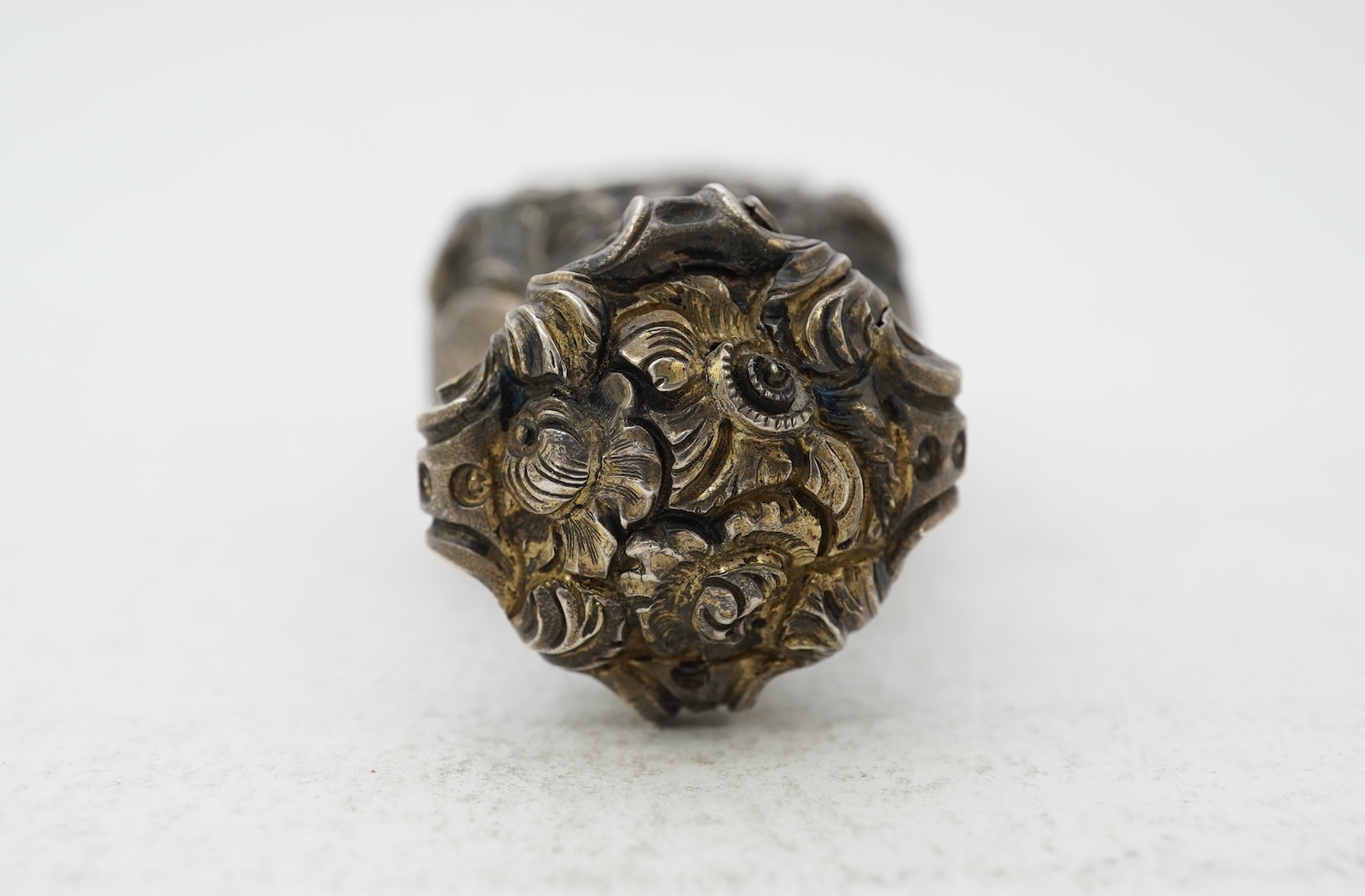 A 19th century French ornate parcel gilt white metal scent flask, with hinged cover and glass stopper